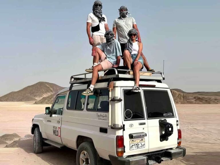 Джип Сафари (после обеда) Хургада 28 Tour group riding on a white Toyota 4WD jeep during a Jeep safari in Hurghada, with travelers in Bedouin headscarves.